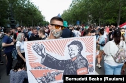 A protester holds a placard depicting Prime Minister Viktor Orban as the late Chinese leader Mao Zedong during June demonstrations in Budapest.