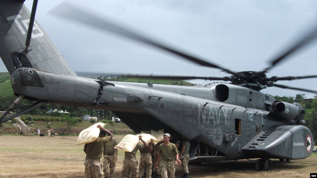 Pakistani soldiers load food supplies for stranded flood victims onto a U.S. Navy helicopter for distribution in August 2010.