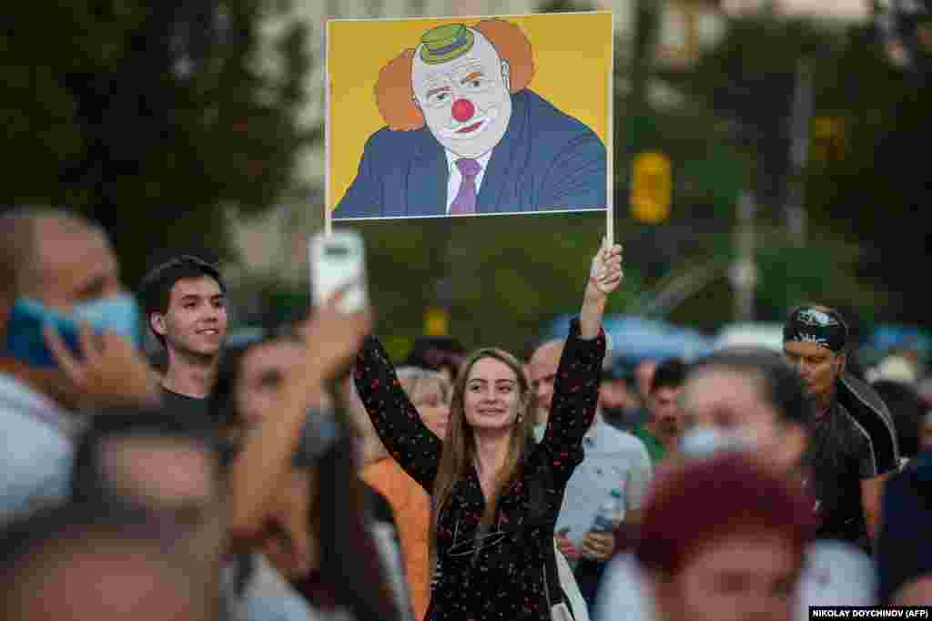 A woman holds a placard depicting Bulgarian Prime Minister Boyko Borisov as a clown during an anti-government protest in Sofia on July 20. (AFP/Nikolay Doychinov)