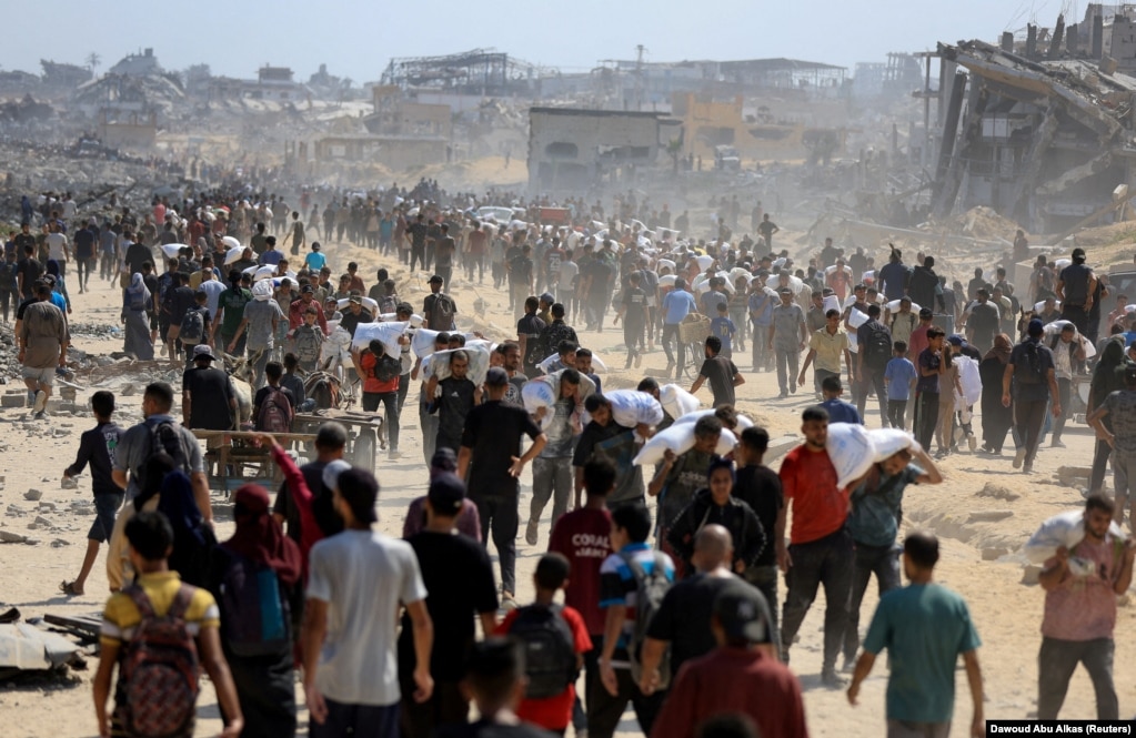 Palestinezë të shumtë duke bartur ndihmat që i morën në Beit Lahia, në veri të Rripit të Gazës, më 20 korrik.