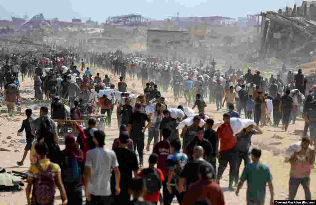 Palestinezë të shumtë duke bartur ndihmat që i morën në Beit Lahia, në veri të Rripit të Gazës, më 20 korrik.