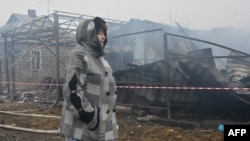 A local resident reacts near her neighbors' house, which was destroyed by a drone strike in Kharkiv, on December 25.