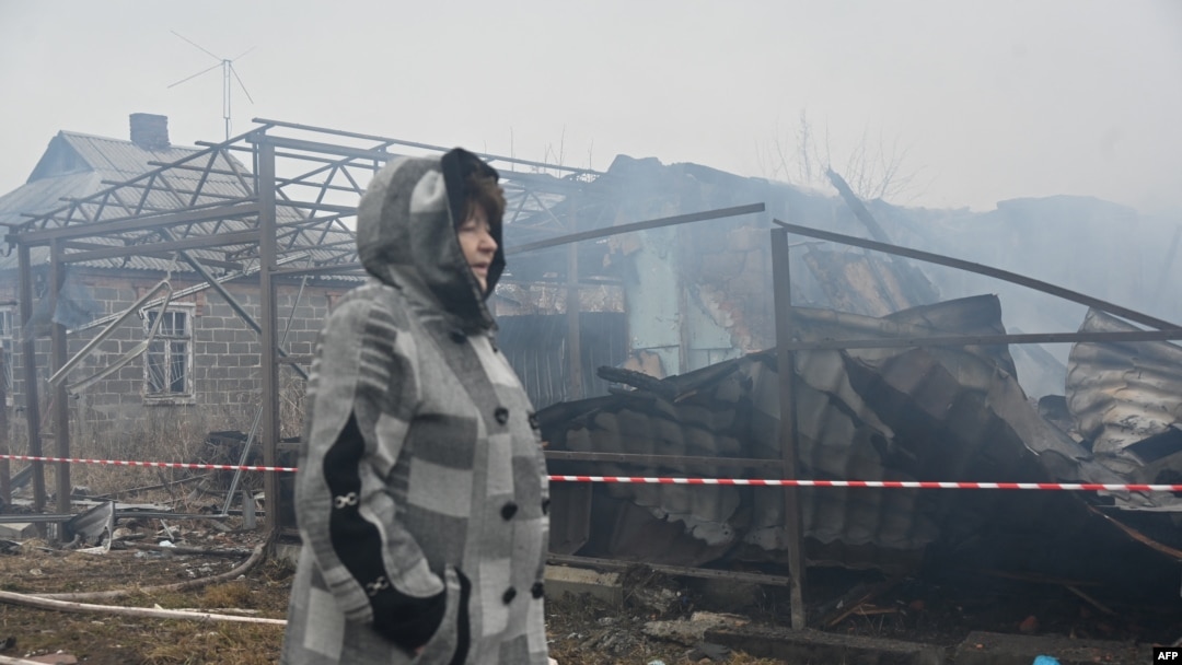 O localnică din Harkov trece prin fața casei vecinilor ei, distrusă de un atac cu drone la Harkov, pe 25 decembrie.