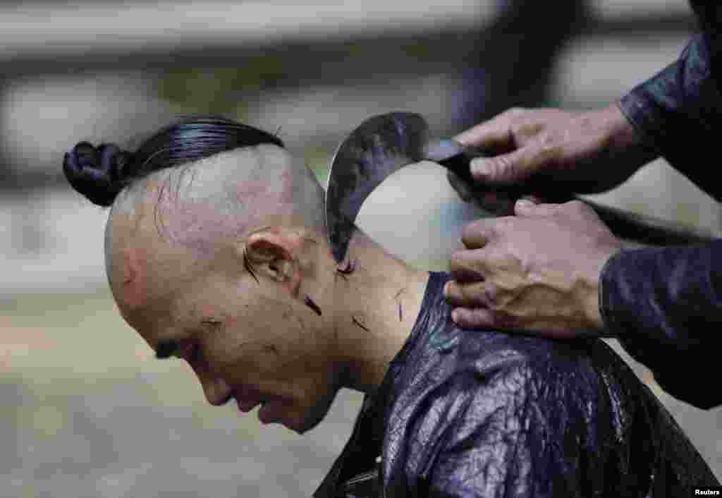 An ethnic Miao minority man shaves another villager&#39;s head with a sickle in China&#39;s Guizhou Province. (Reuters/Jason Lee)