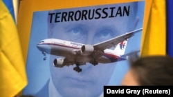 Перший рік війни Росії проти України. Зображення Володимира Путіна на плакаті учасників акції протесту в столиці Австралії через два дні після збитого 17 липня російськими гібридними силами на Донбасі «Боїнга», в результаті чого загинули 298 людей. Сідней, 19 липня 2014 року