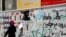 An Iranian woman walks past campaign posters in Tehran on June 8.