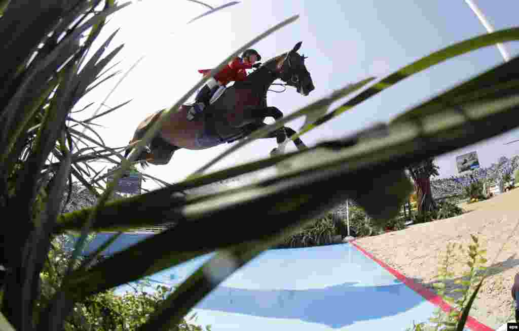 U.S. rider McLain Ward takes the water jump at the Olympic Equestrian Center in Deodoro.