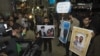 Iranian students hold up pictures of Iranian scientist Mostafa Ahmadi-Roshan, who was killed in a bomb blast on January 11, as they wait for the arrival of the IAEA delegates at Tehran's Imam Khomeini International Airport on January 29.