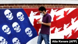 A man walks past a mural painted on the outer walls of the former U.S. Embassy in Tehran.