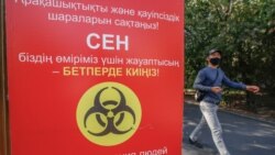 Мужчина проходит мимо надписи, предупреждающей об опасности коронавируса.