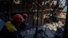 Рабочие стоят возле поврежденной теплоэлектростанции ДТЭК после российской атаки на Украину, 2 мая 2024 года