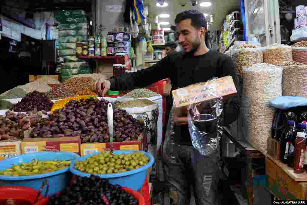 Një palestinez shet hurme dhe gjësende të tjera në tregun Zavija në Qytetin e Gazës më 28 shkurt 2025.