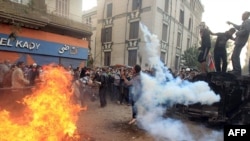 An Egyptian protester throws back a tear-gas canister on the third day of clashes with security forces at Tahrir Square in Cairo on November 21.