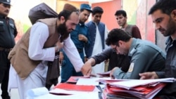 A Taliban prisoner (left) is processed for release at Pul-e Charkhi prison in Kabul on August 13.