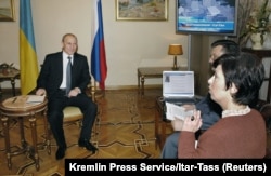 Vladimir Putin listens to a viewer's question during an appearance on Ukrainian television while on a visit to Kyiv on October 26, 2004.