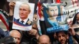 People hold posters of Russian President Vladimir Putin and Syrian President Bashar al-Assad during a rally in support of Russia's military invasion of Ukraine, in front of UN headquarters in Beirut in March 2022.