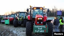 Bujqit gjermanë rreshtohen për ta bllokuar një autostradë në Birkenwerder, Gjermani, në protestë kundër ndaljes graduale të subvencioneve bujqësore, 8 janar 2024.