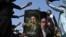 TOPSHOT - A Shia Muslim holds a poster with portraits of Iran's supreme leader Mojtaba Khamenei and late supreme leader Ayatollah Ali Khamenei (L) as mourners take part in a procession on the ninth day of the Islamic holy month of Muharram in Islamabad on