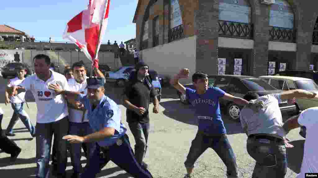 A policeman (center) tries to stop supporters of the ruling National Movement Party as they scuffle with advocates of the opposition Georgian Dream coalition during an election rally in the town of Signagi on September 26. (Reuters)