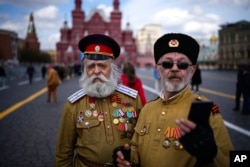 Doi bărbați în uniforme de cazaci după o vizită la Mausoleul lui Lenin, pe 22 aprilie 2024, la Moscova.