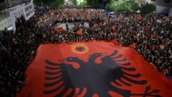 Protestuesit e shpalosin një flamur kombëtar shqiptar me emblemën e UÇK-së ndërsa protestojnë kundër një vendimi të gjykatës së Hagës, e cila dënoi ish-udhëheqës të UÇK-së për krime lufte, Prishtinë 20 shtator 2026.