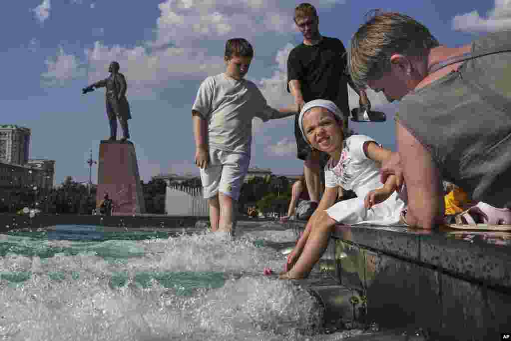 People cool down at a fountain in St. Petersburg, Russia.
