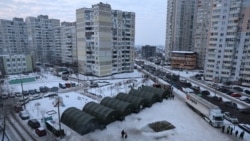 Мобільні пункти обігріву де жителі Києва посеред житлових кварталів. Там можна зігрітися, випити чаю чи кави, зарядити телефони та отримати допомогу під час відключень світла й опалення. Київ, 25 січня 2026 року