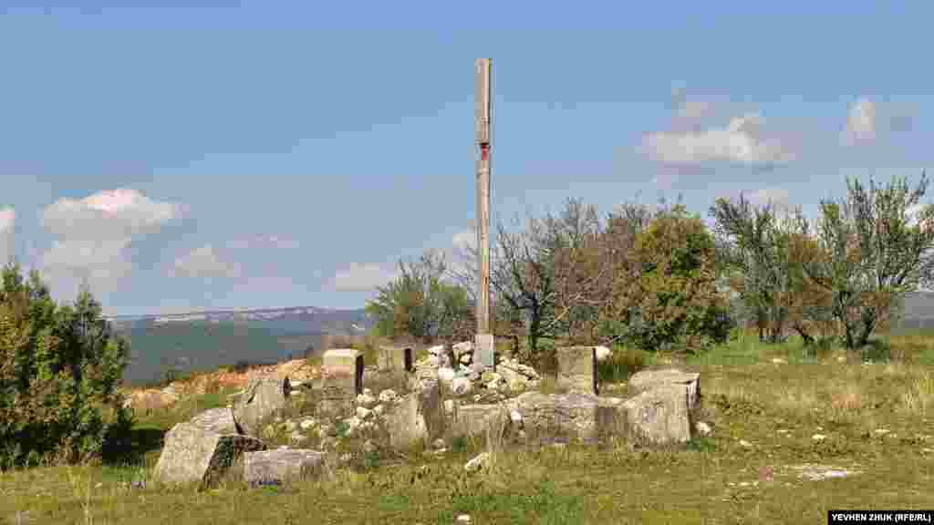 Камни бывшей кладбищенской часовни и остатки современного деревянного креста, установленного в 2018 году во время частного визита итальянцев в Севастополь