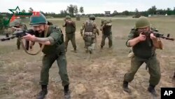In this photo taken from video released by Belarusian Defense Ministry on July 14, Belarusian soldiers attend training with Wagner fighters near Tsel, about 90 kilometers southeast of Minsk, Belarus. 