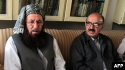 Tehrik-e Taliban Pakistan committee member and senior religious party leader Maulana Sami-ul-Haq (left) holds talks with special assistant to Pakistan's prime minister Irfan Siddiqui during a meeting in Akora Khattak on March 5.