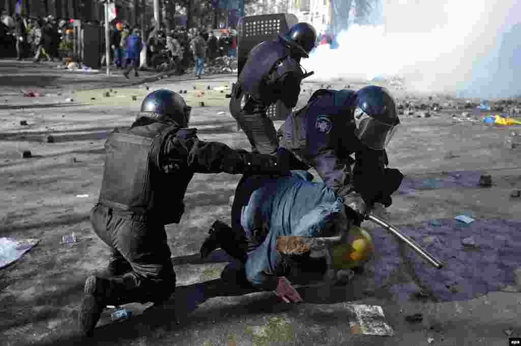 Riot police detain a protester on February 18.