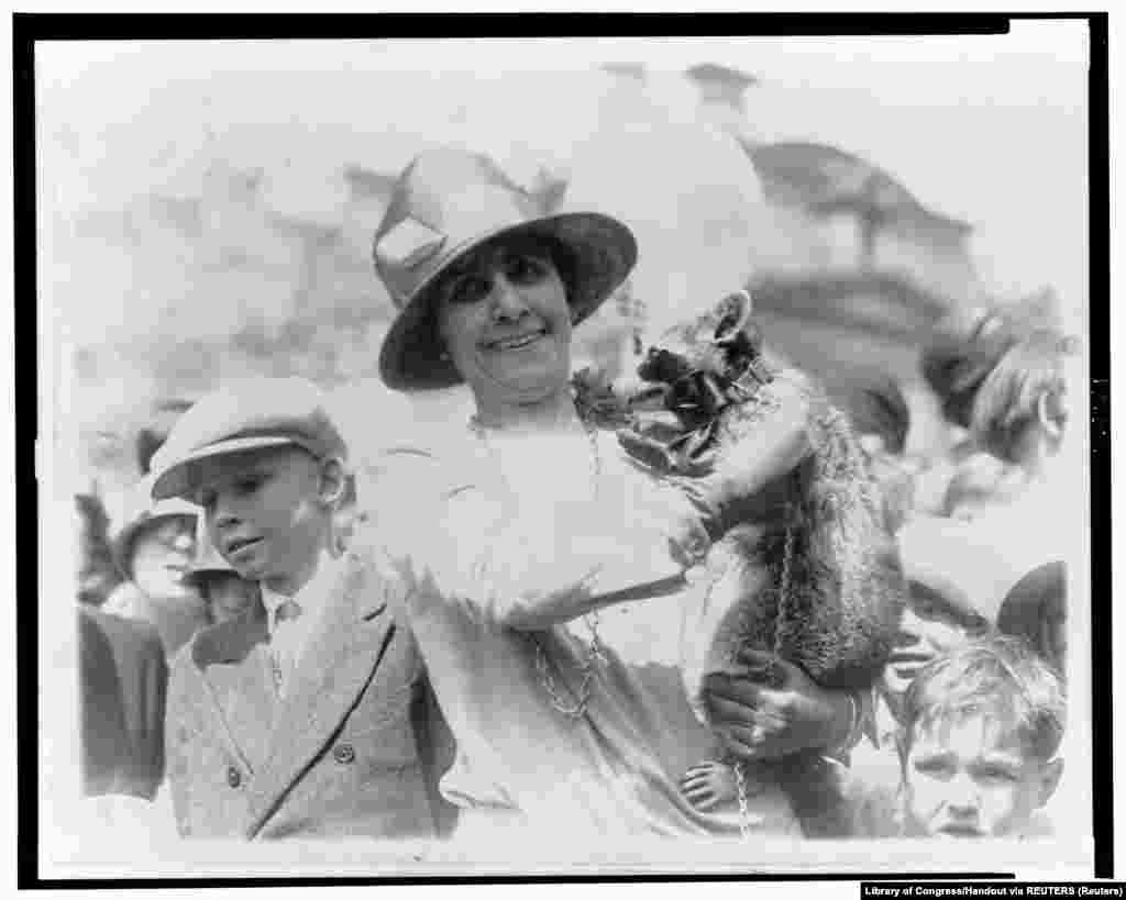 18 апреля 1927 года. Первая леди Грейс Кулидж, жена 30-го президента Калвина Кулиджа, во время Пасхального обеда в Белом доме показывает детям домашнего любимца семьи &ndash; енота Ребекку