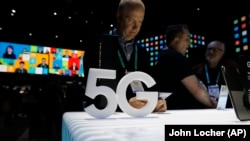 Люди смотрят на телефоны 5G на стенде Samsung во время технической выставки CES во вторник, 7 января 2020 года, в Лас-Вегасе. 