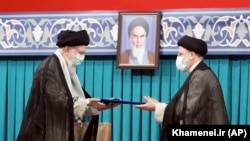 IRAN -- Iranian Supreme Leader Ayatollah Ali Khamenei, left, gives his official seal of approval to newly elected President Ebrahim Raisi in an endorsement ceremony in Tehran, August 3, 2021