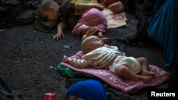 Children of Uyghurs from China's western region of Xinjiang rest inside a temporary shelter in Thailand.