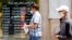 IRAN -- An Iranian man checks the currency rate as he walks past a currency exchange service in Tehran, Iran, 22 June 2020. 