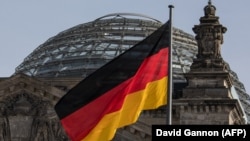 Флаг Германии у здания парламента в Берлине. Иллюстративное фото. 