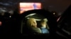 Two women are seen inside their car at a drive-in cinema, as the spread of the coronavirus disease (COVID-19) continues in Essen, Germany, March 29, 2020. REUTERS/Leon Kuegeler