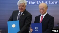 یوکیا آمانو (راست) در کنار ارلان ادریسوف،نخست وزیر قزاقستان، پس از امضای قرارداد بانک سوخت اتمی در سال ۹۴
