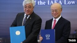 یوکیا آمانو (راست) در کنار ارلان ادریسوف، نخست وزیر قزاقستان، پس از امضای قرارداد بانک سوخت اتمی