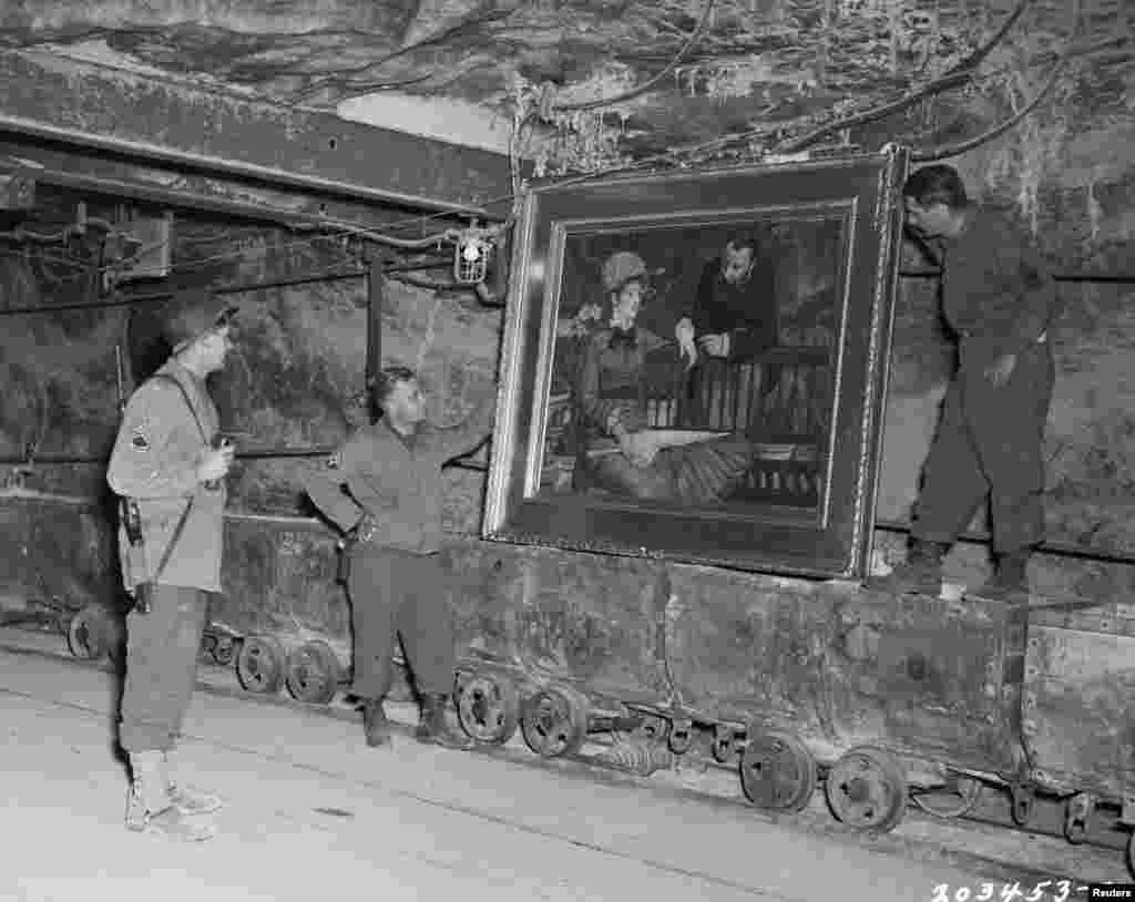 U.S. soldiers examine the painting, &quot;Wintergarden,&quot; by French Impressionist painter Edouard Manet. It was stolen by the Nazi regime and hidden in a salt mine in central Germany. The artwork was recovered in 1945 and was not among those discovered in the Munich apartment in 2012.