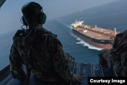 US Navy Adm. Brad Cooper, commander of US Central Command, observes a commercial vessel transiting the Strait of Hormuz while flying in a US Army CH-47 Chinook over the international waterway on October 25. (US Central Command photo)