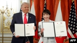 دونالد ترامپ (چپ)، رئیس‌جمهور آمریکا، و سانائه تاکایچی، نخست‌وزیر ژاپن، در مراسم امضای سندی در مورد اجرای توافق تجاری آمریکا و ژاپن، عکس یادگاری گرفتند