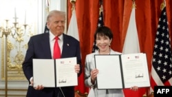 Президент США Дональд Трамп та прем’єр-міністр Японії Санае Такаїчі позують під час церемонії підписання документа про виконання торговельної угоди між США та Японією в гостьовому будинку Akasaka State у Токіо, 28 жовтня 2025 року