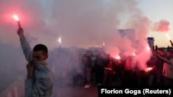 Opposition protesters hold up flares at the main entrance road of Tirana on May 2, 2019