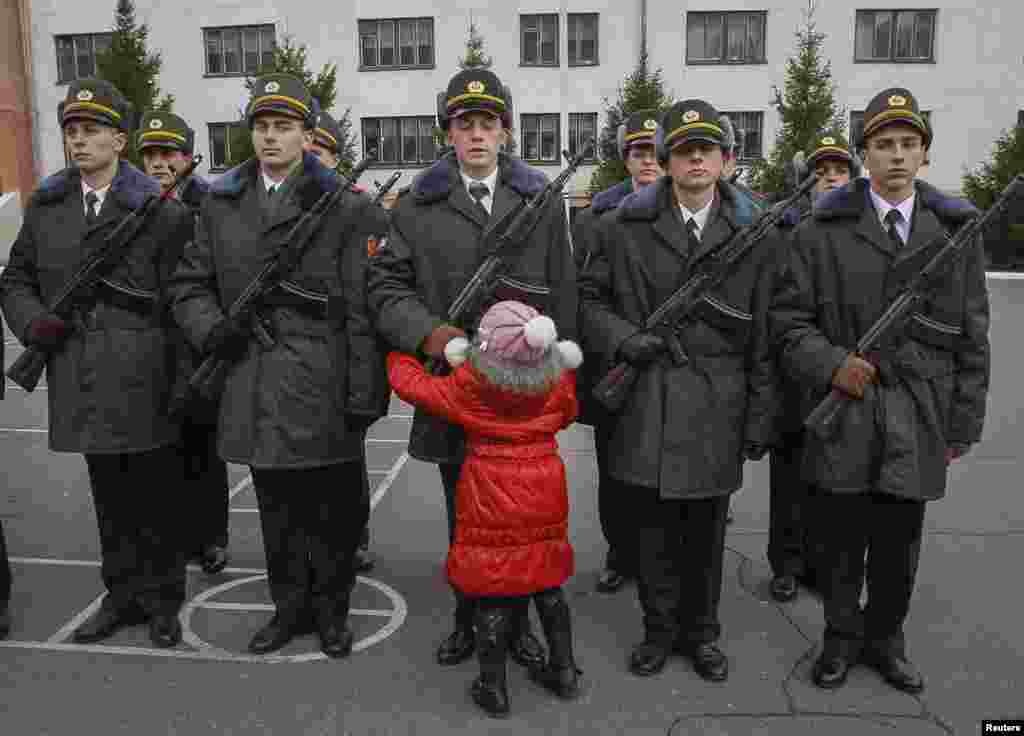 A girl hugs her brother, a recruit from the presidential regiment, as he takes the oath at a military base in Kyiv. (Reuters/Gleb Garanich)