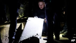 Ukrainian soldiers inspect a part of a drone that was downed in downtown Kyiv. (file photo)