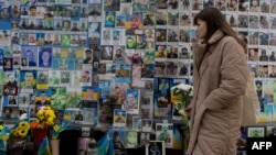 Žena polaže cveće pored Zida sećanja na pale za Ukrajinu, Kijev, 24. februar 2026.