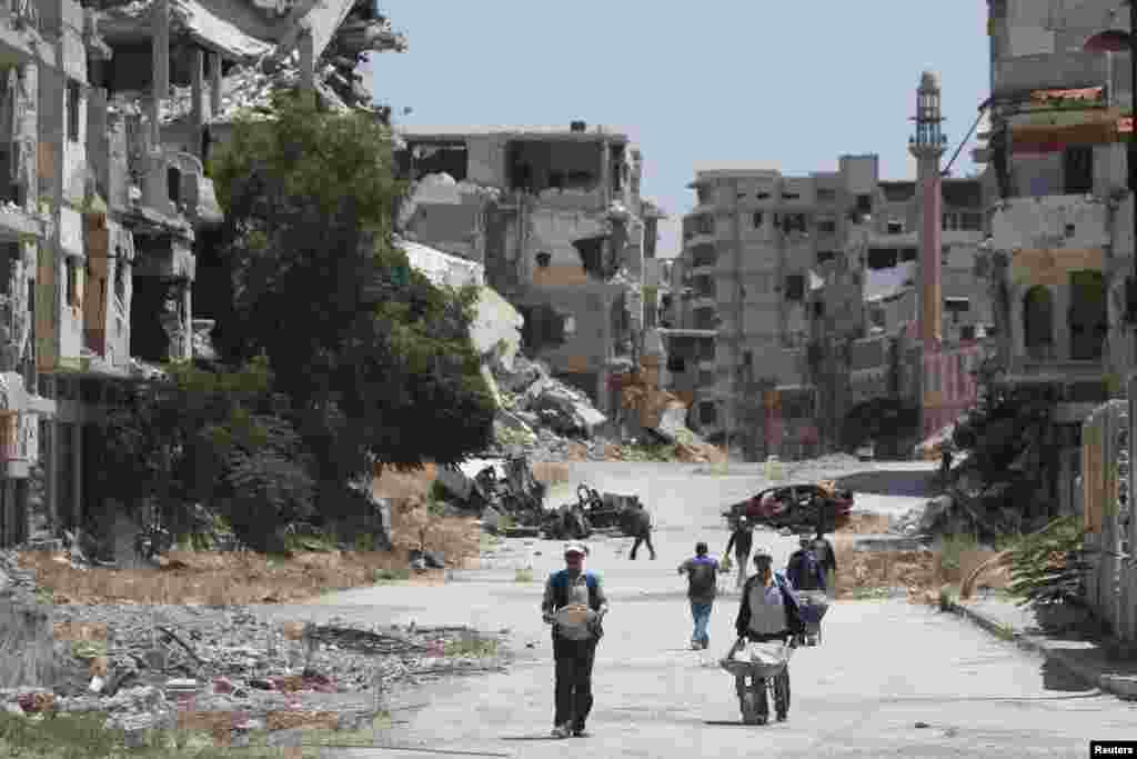 Workers collect the rubble of damaged buildings for recycling and reuse during reconstruction under the supervision of the UN Development Program in the Syrian city of Homs. (Reuters/Omar Sanadiki)