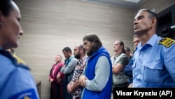 Kosovo police officers stand guard as the convicted plotters are sentenced in Pristina on May 18. 